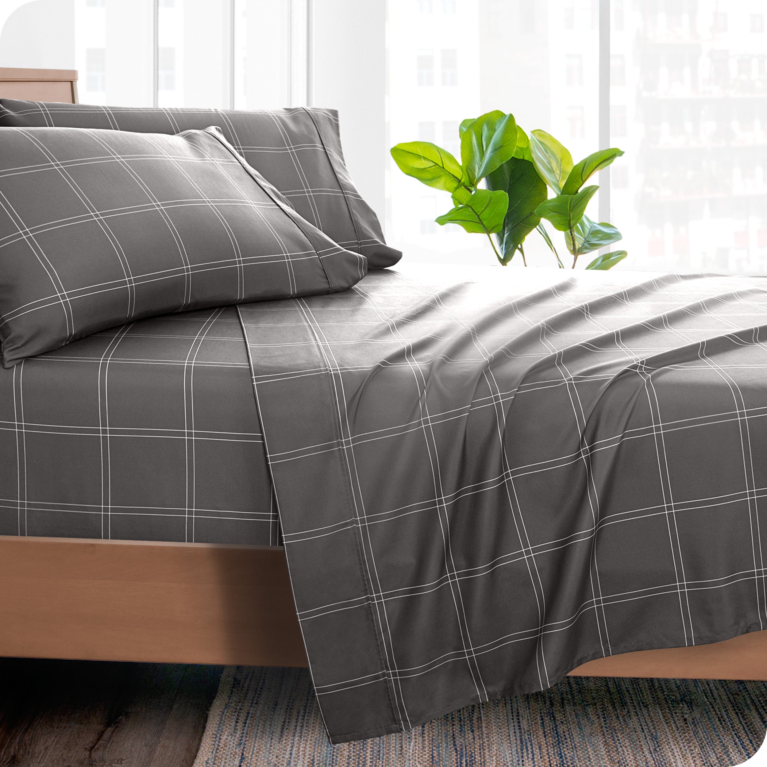 Side of a bed made with a draped microfiber flat sheet. 