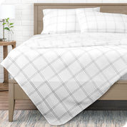 View from end of a modern bed with microfiber flat sheet draped over. 
