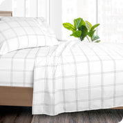 Side of a bed made with a draped microfiber flat sheet. 