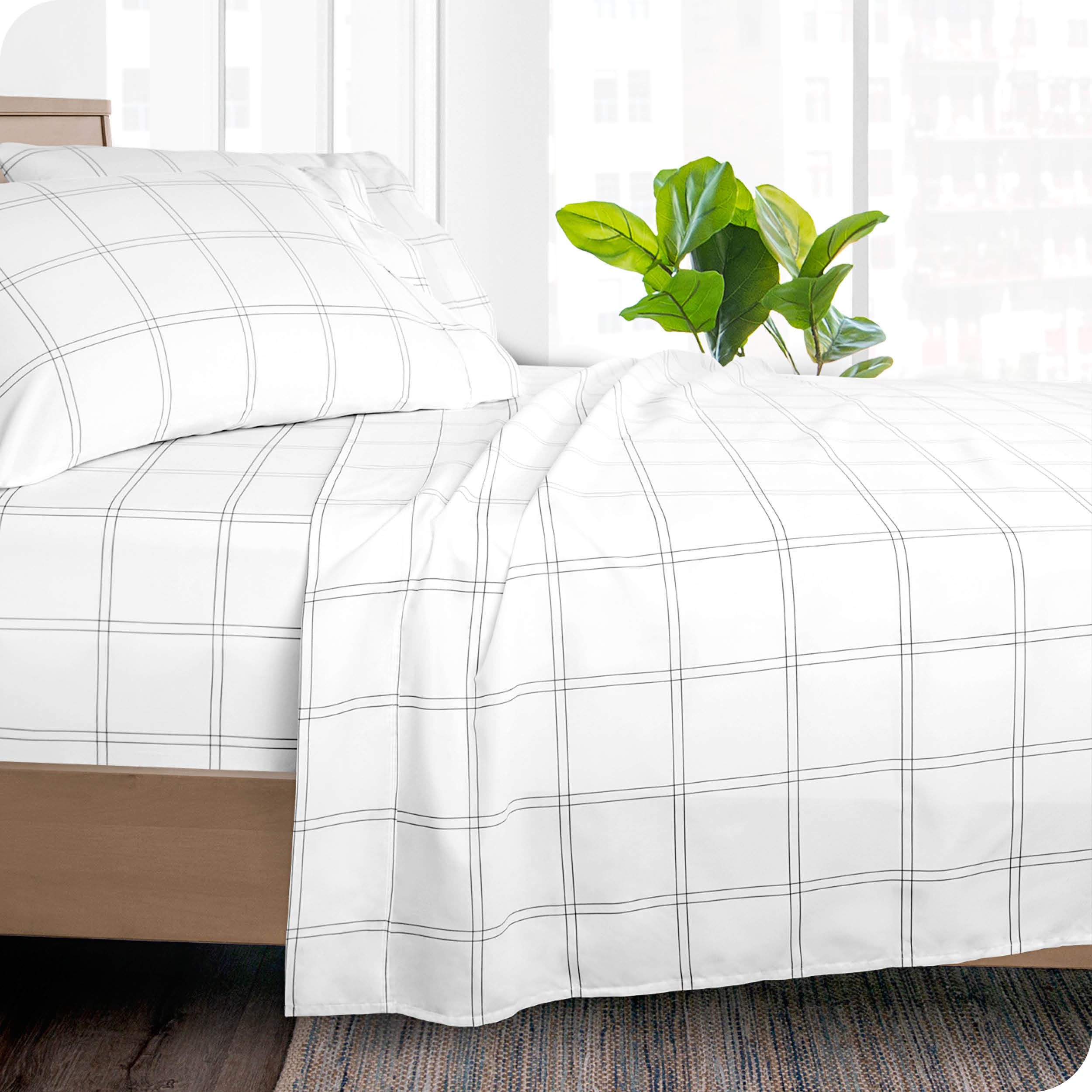 Side of a bed made with a draped microfiber flat sheet. 
