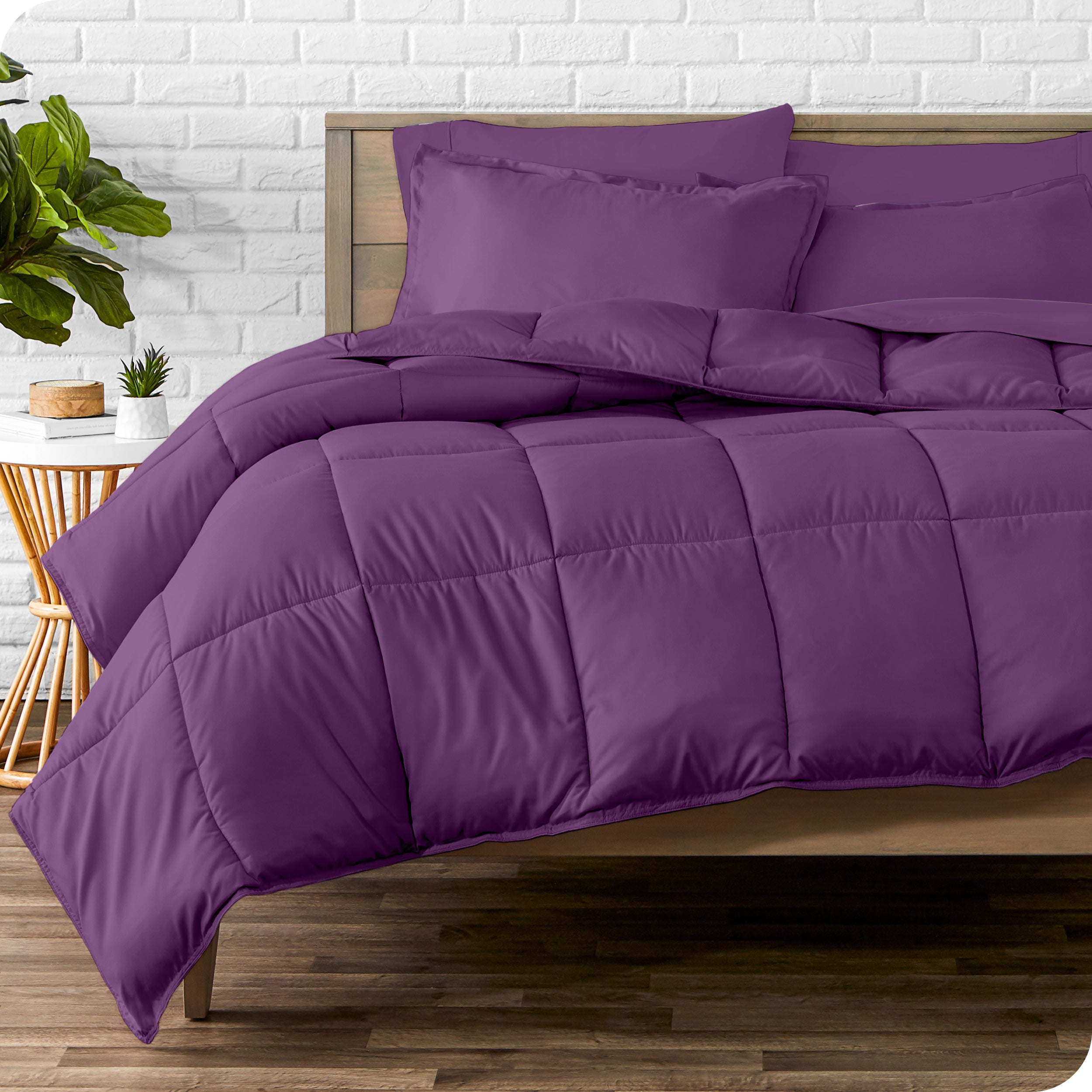 A wooden bed frame with sheets, pillow shams and a comforter on the bed