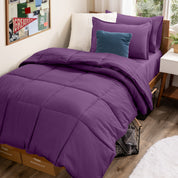 A college dorm room with a bed in a bag set on the mattress