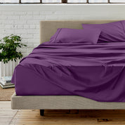 Microfiber sheet set on a bed with a white brick wall in the background