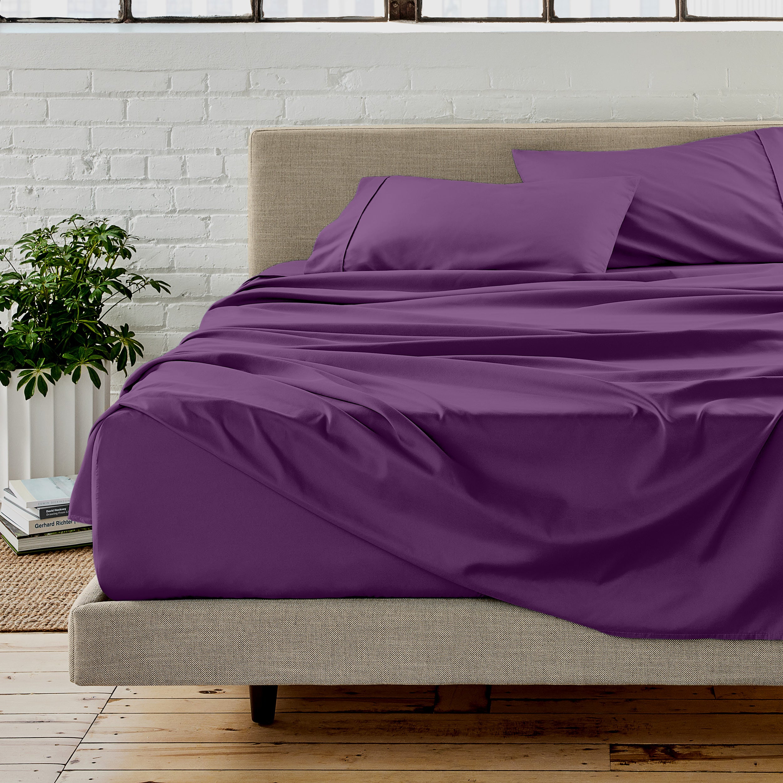 Microfiber sheet set on a bed with a white brick wall in the background