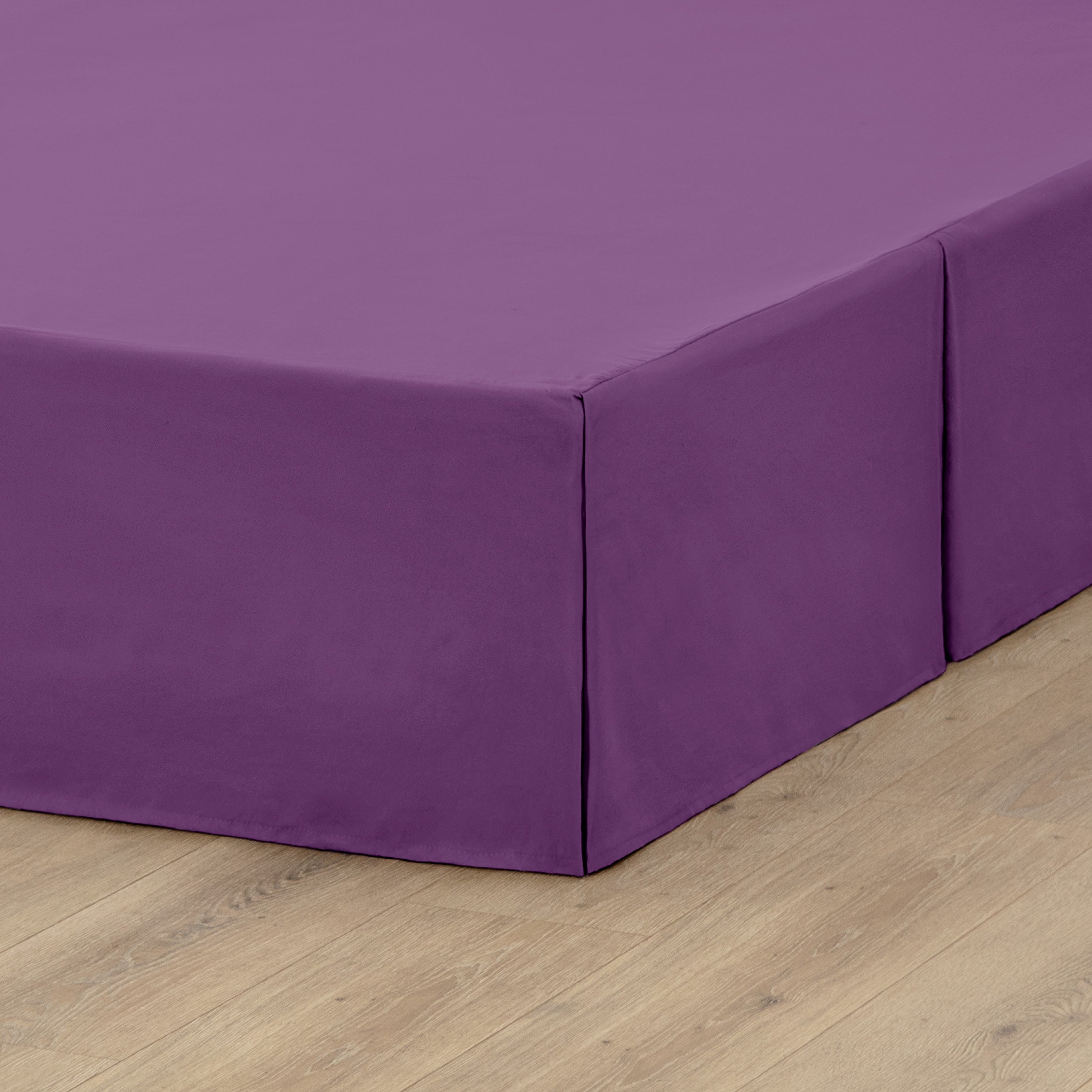 A box spring with a bed skirt on it