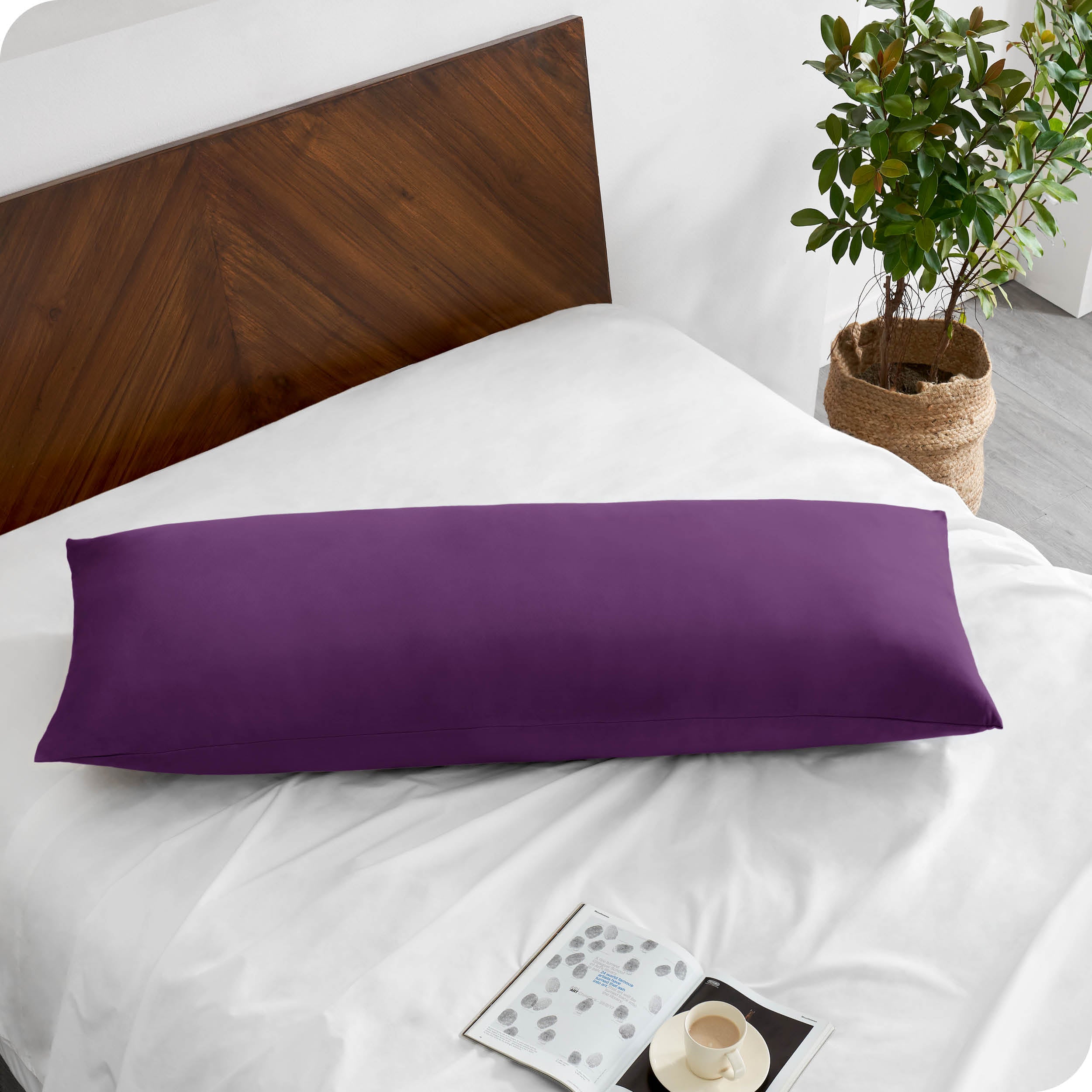 A body pillowcase on a pillow on a bed with all white bedding