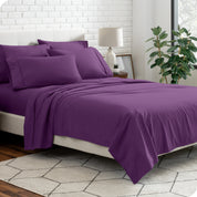 A bedroom setting with a bed made with the microfiber bed sheets and four pillows.