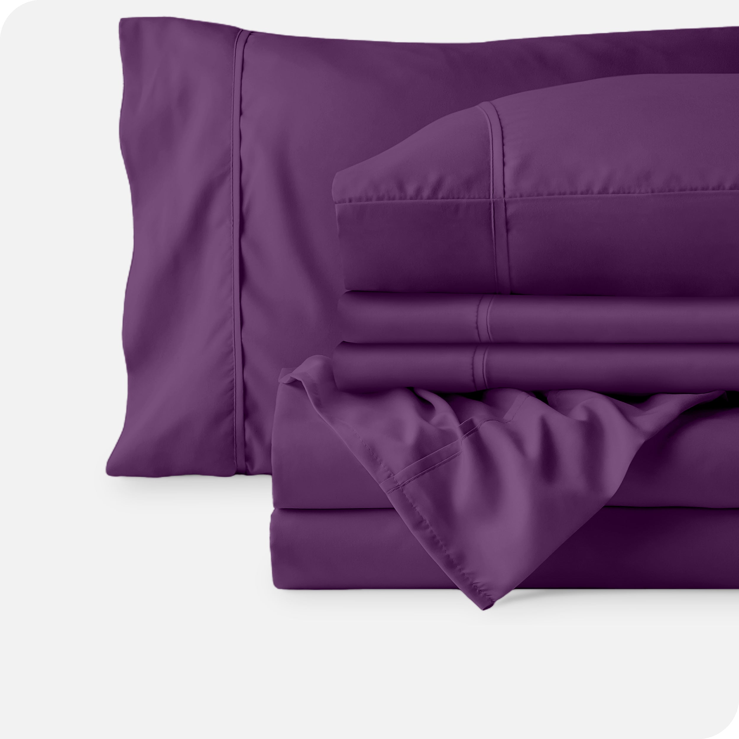 Microfiber sheets neatly folded with corner draped over, two folded pillowcases and two display pillows.
