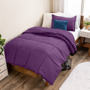 A modern bed with a down alternative comforter set on it