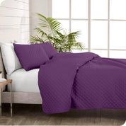 A coverlet set on a bed next to a window