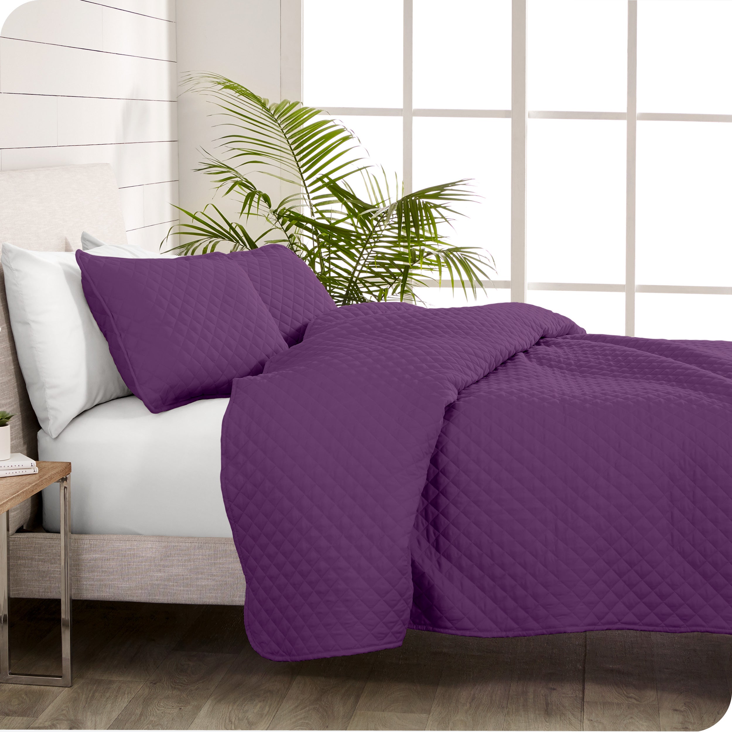 A coverlet set on a bed next to a window