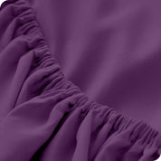A close up of the elastic of a microfiber fitted sheet. 