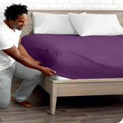 A man putting the microfiber fitted sheet on a mattress. 
