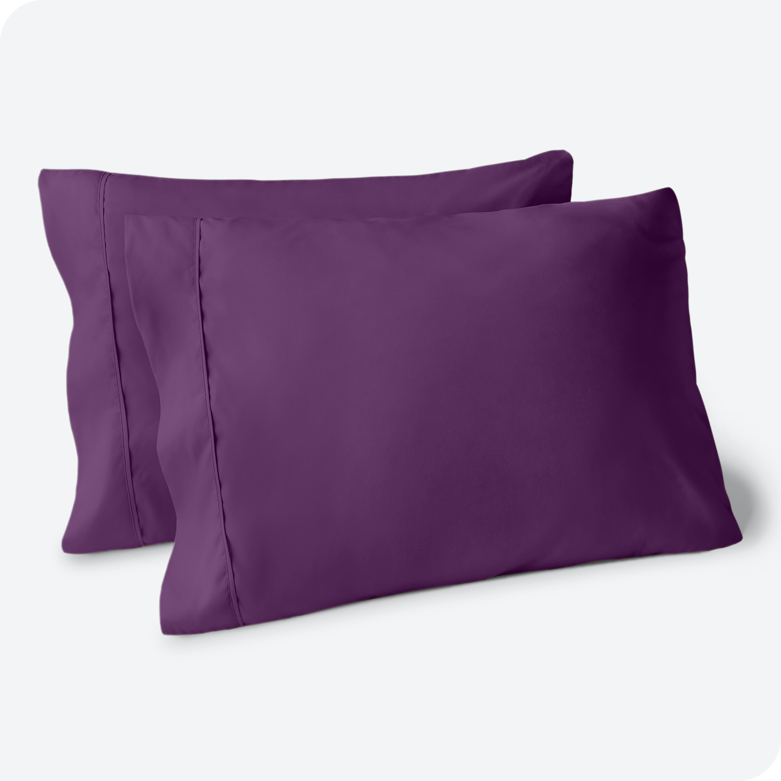 Two pillows on a white background with blue pillowcases on them