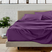 Microfiber sheets on a bed with a brick wall behind it