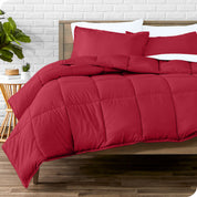 A wooden bed frame with sheets, pillow shams and a comforter on the bed
