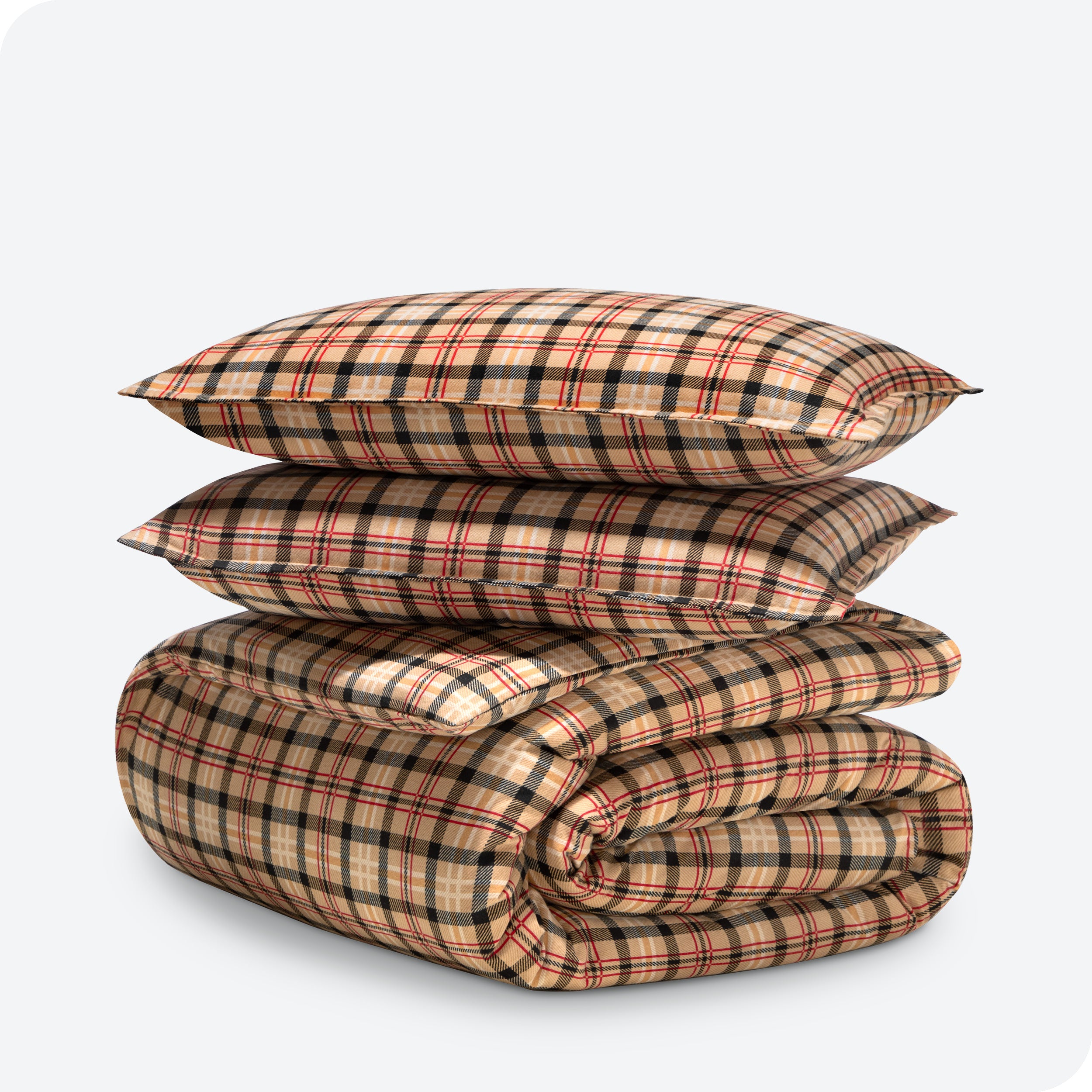 A folded stack of a printed flannel duvet cover with two pillows on top.