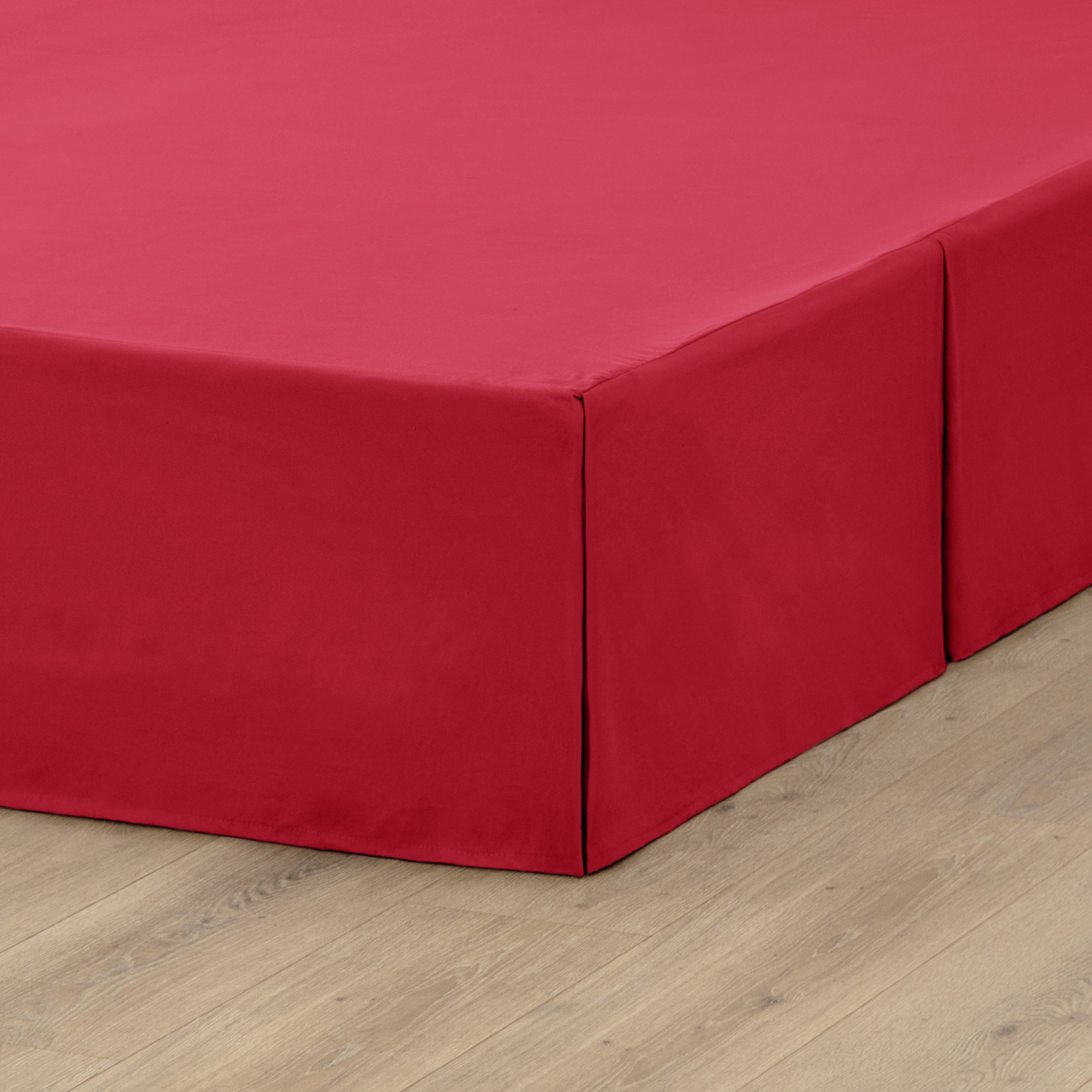 A box spring with a bed skirt on it