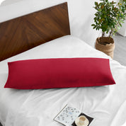 A body pillowcase on a pillow on a bed with all white bedding