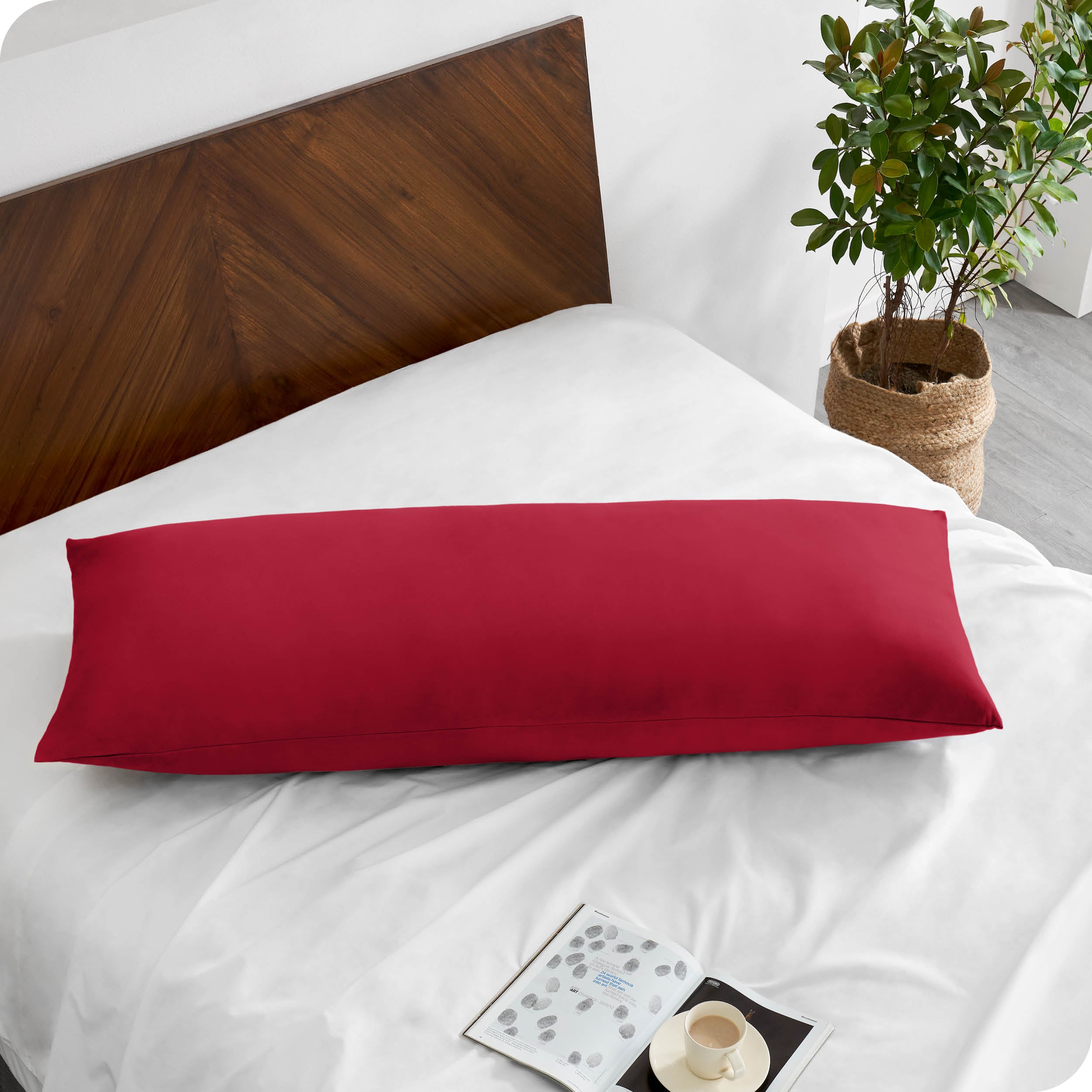 A body pillowcase on a pillow on a bed with all white bedding