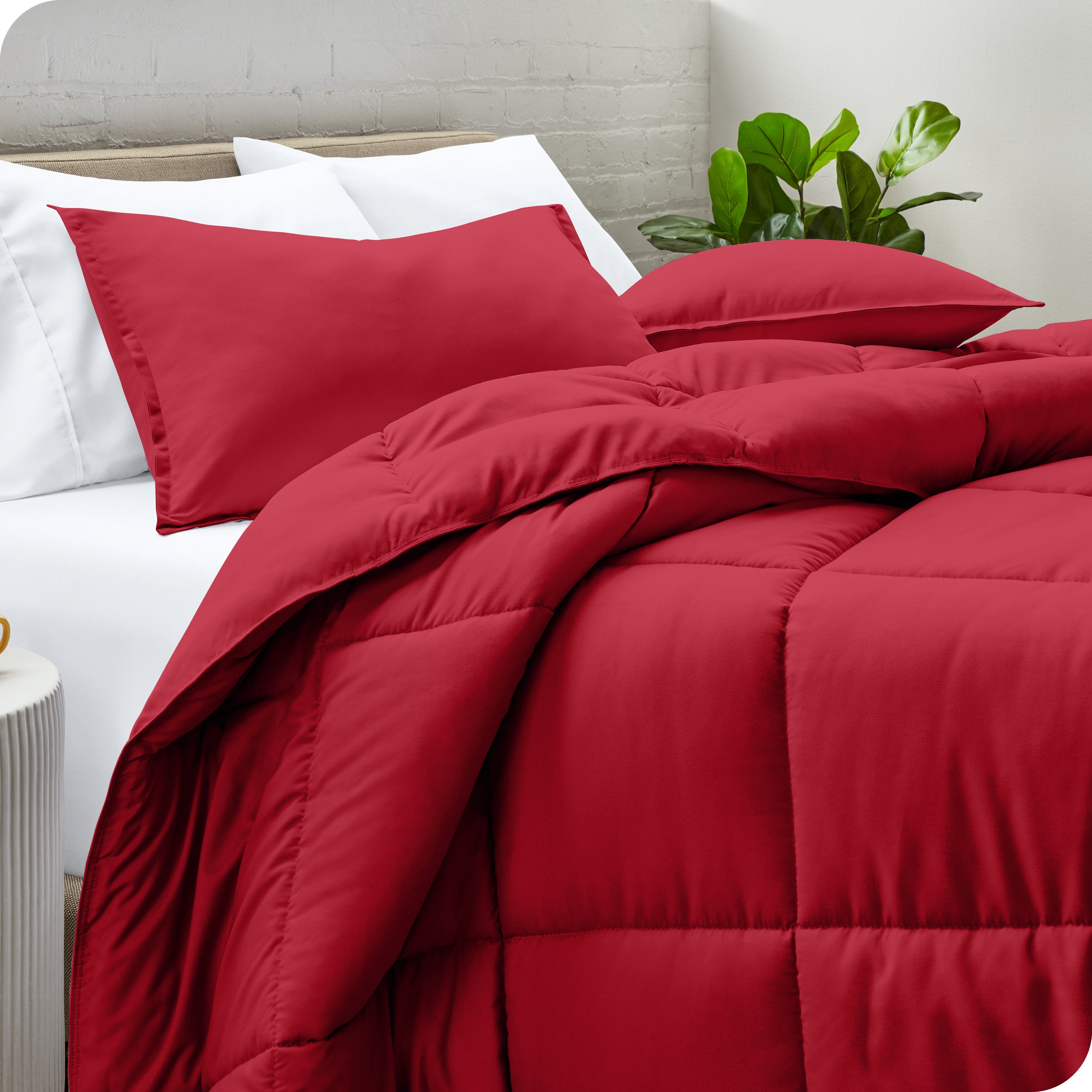 A side view of a modern bed with a comforter set and pillows on the bed