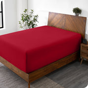 A wide corner view of a modern bed made with a microfiber fitted sheet on the mattress. 