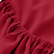 A close up of the elastic of a microfiber fitted sheet. 