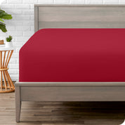 A modern bed with a fitted microfiber sheet on it