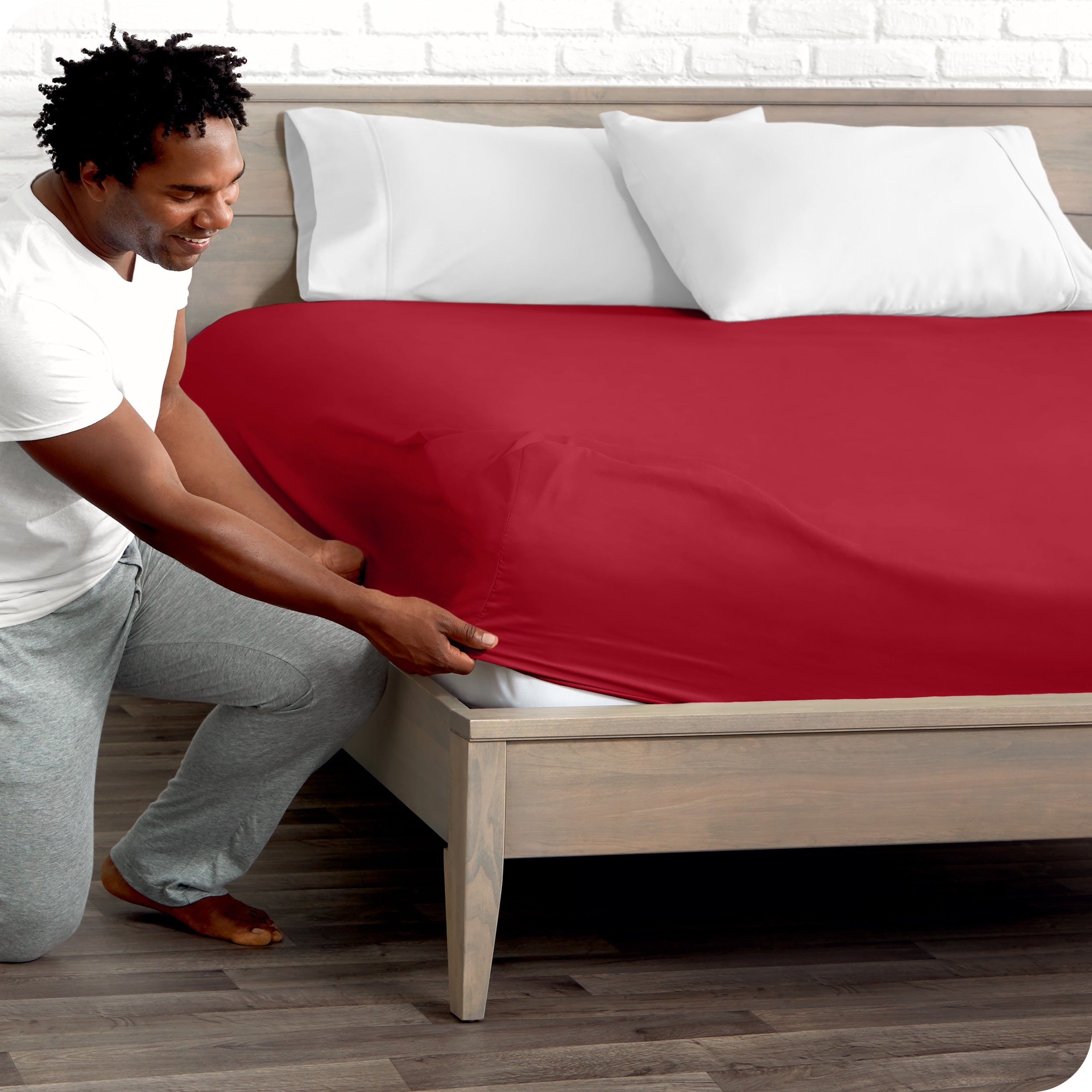 A man putting the microfiber fitted sheet on a mattress. 