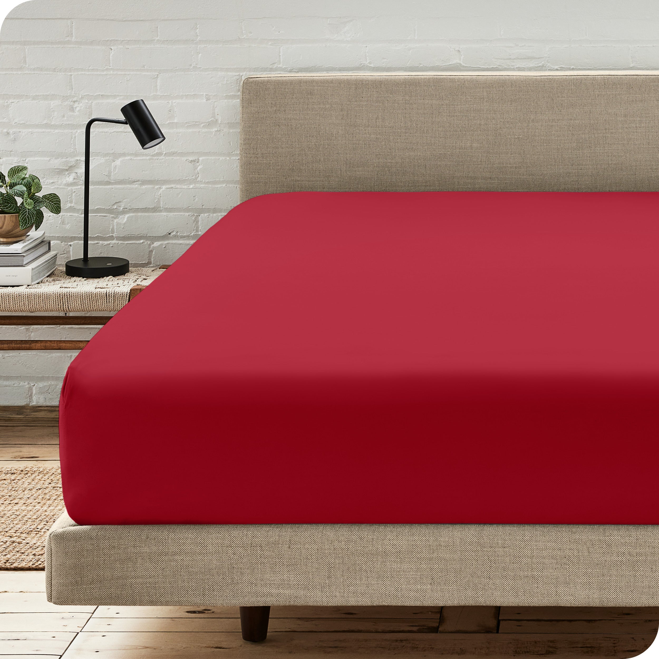 A bed with a microfiber fitted sheet on the mattress. 