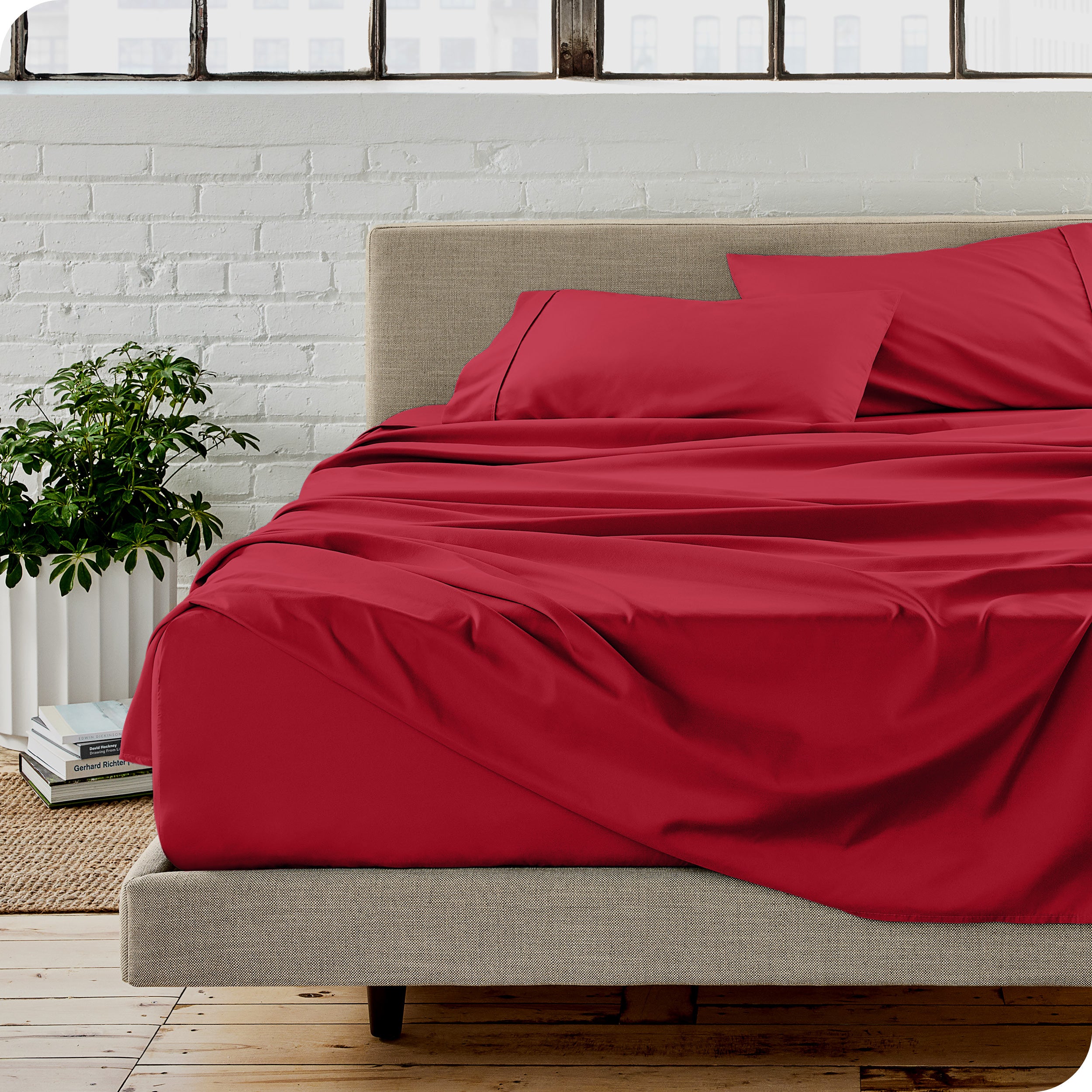 Microfiber sheets on a bed with a brick wall behind it