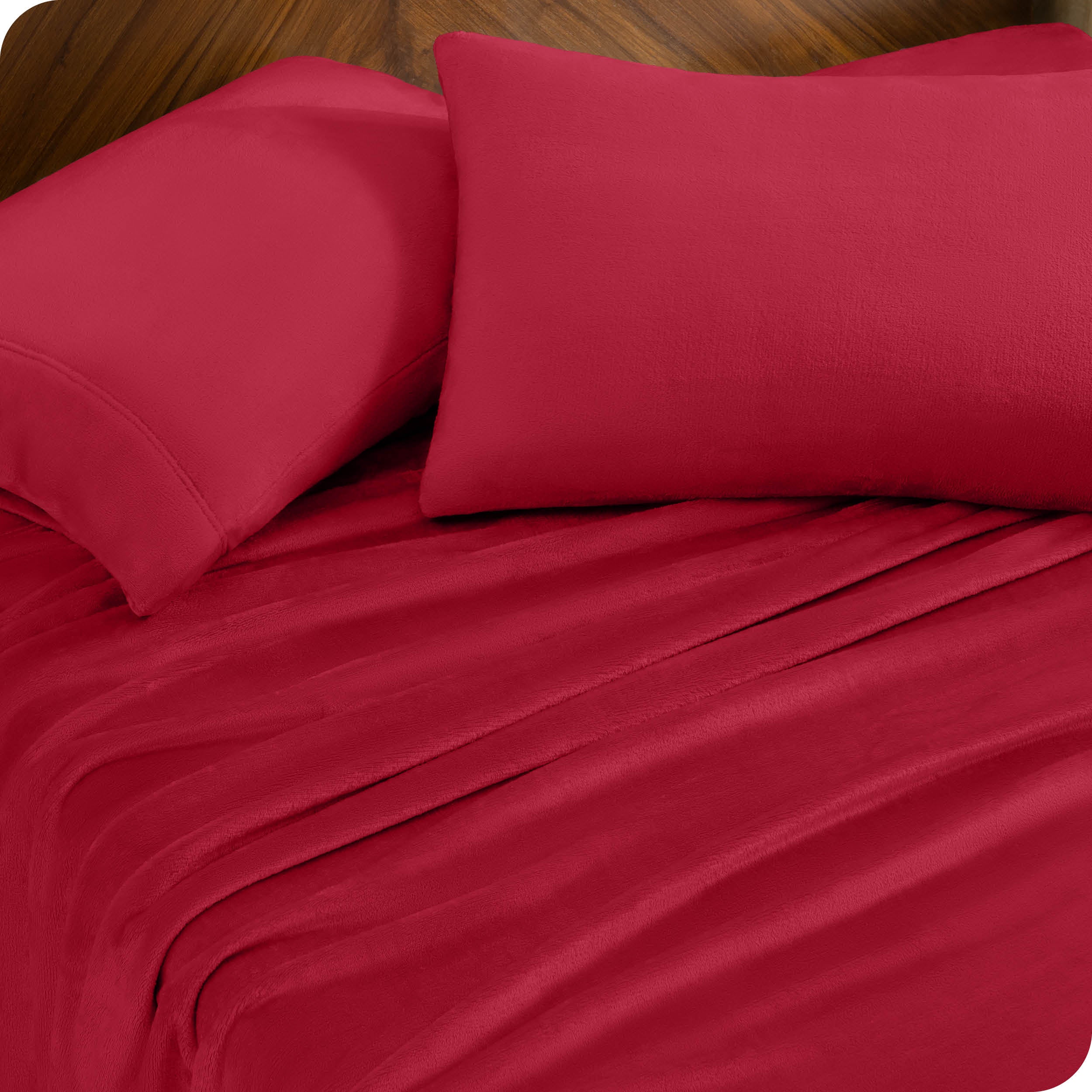 Two pillows with pillowcases on them set on a bed with matching sheets