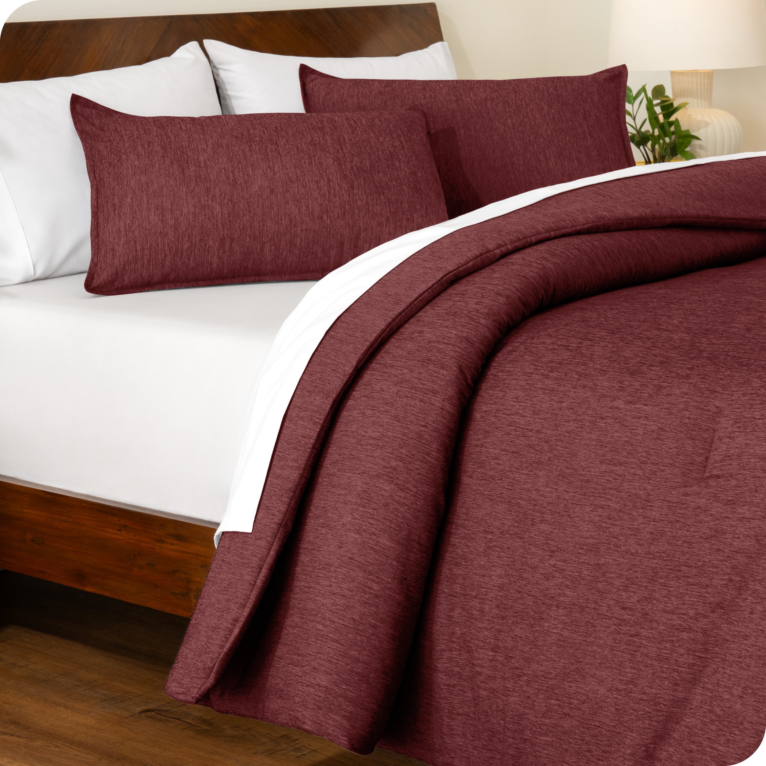 A side view of a modern bed with a comforter set and pillow shams on the bed
