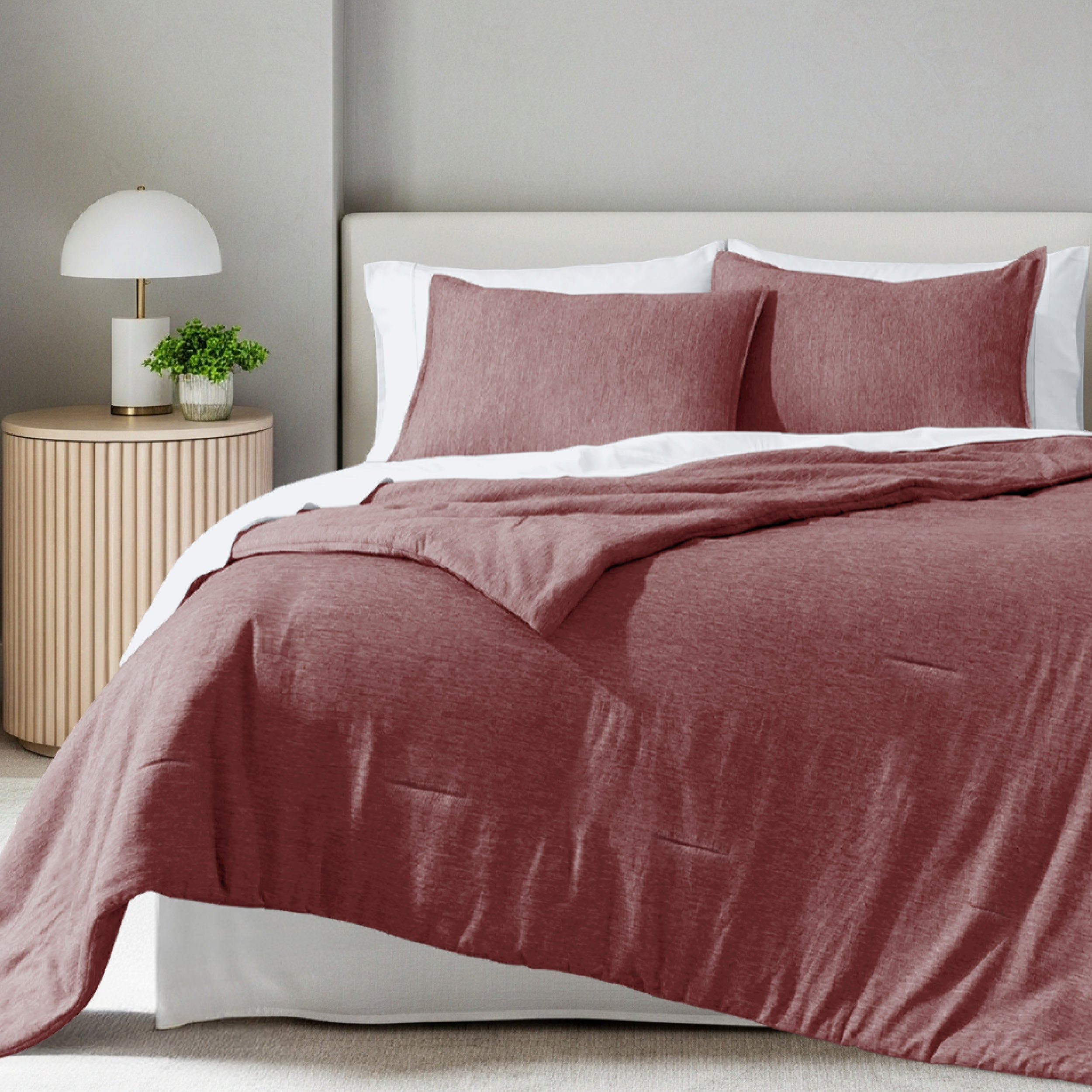 A comforter set on a bed in a bright modern room
