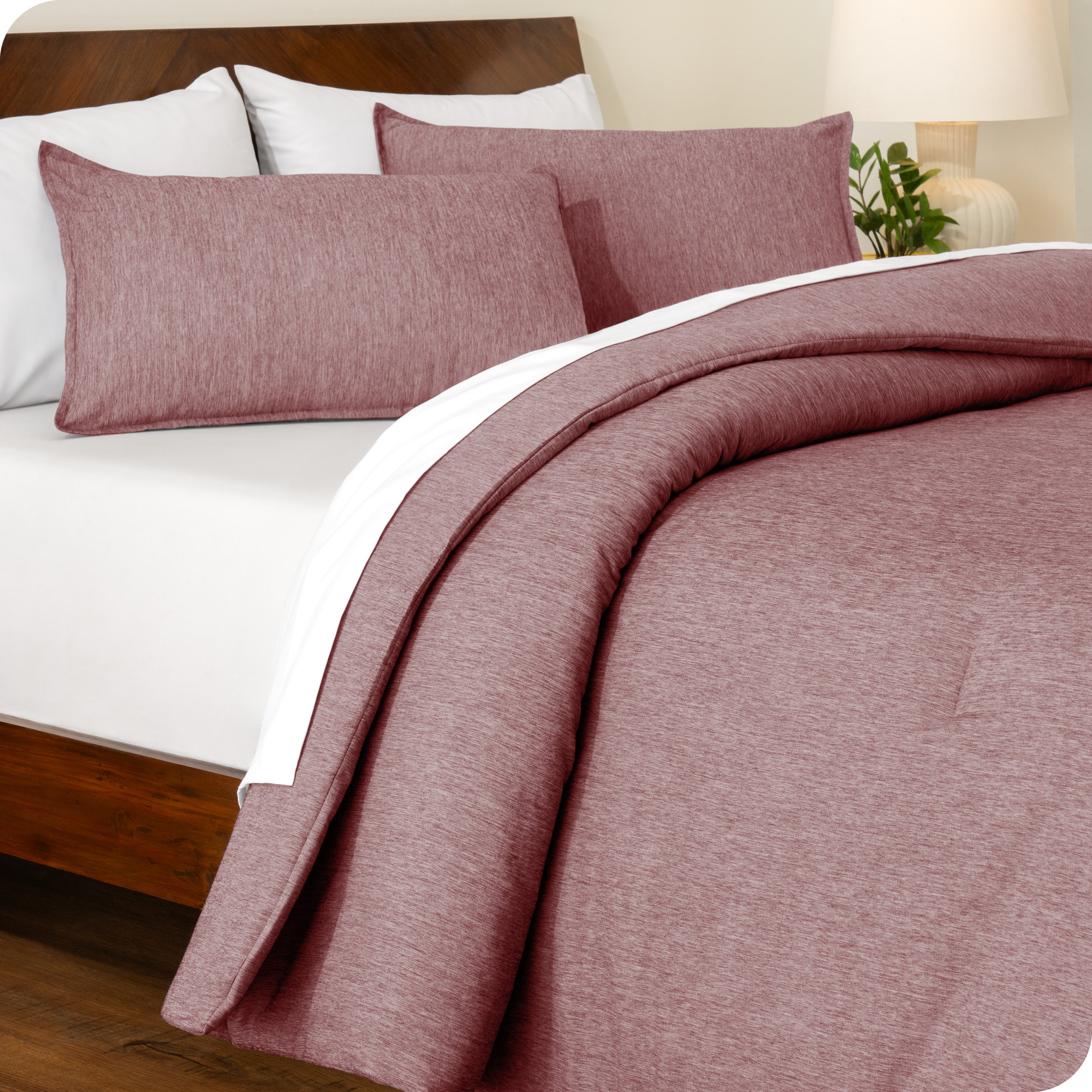 A side view of a modern bed with a comforter set and pillow shams on the bed
