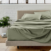 Microfiber sheets on a bed with a brick wall behind it