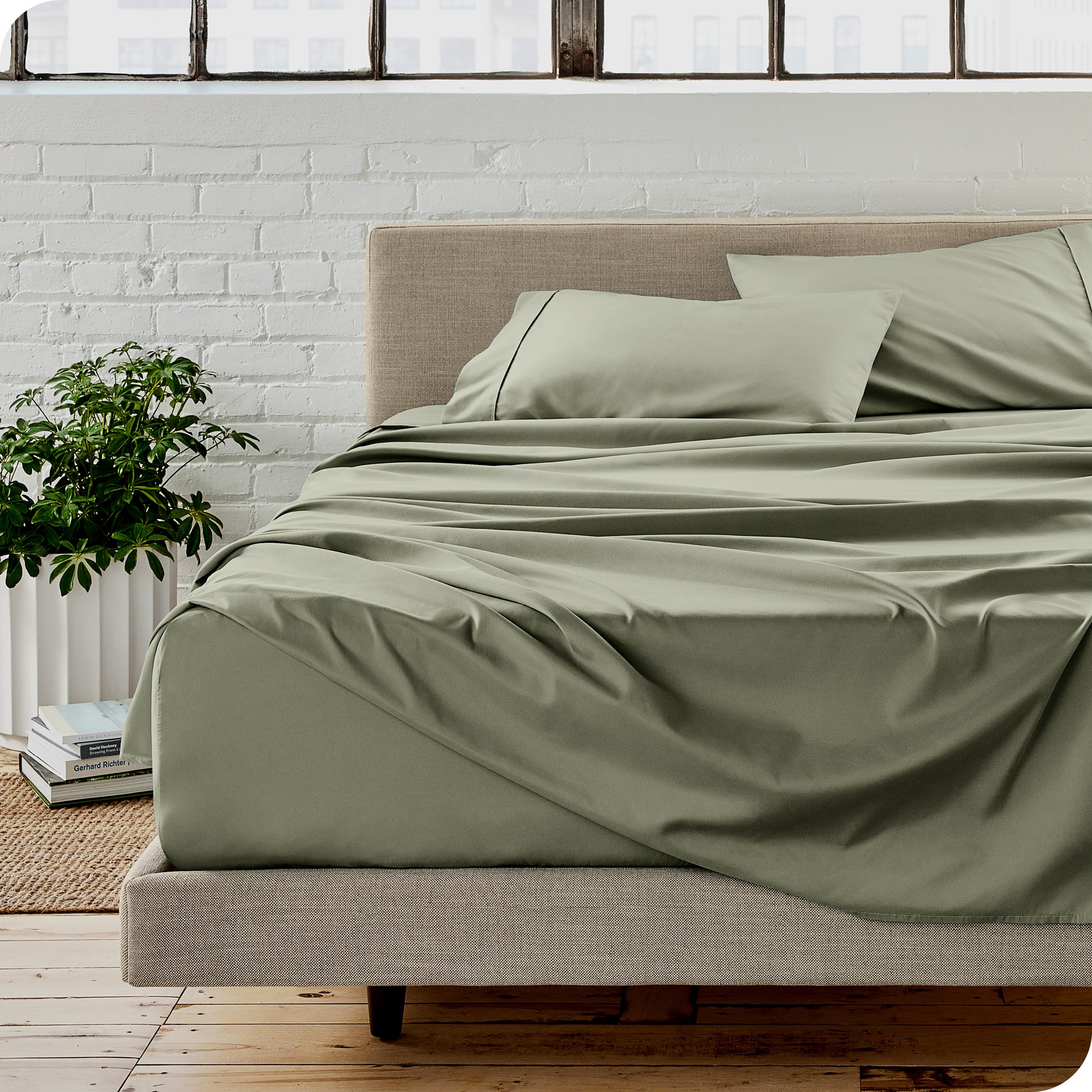 Microfiber sheets on a bed with a brick wall behind it
