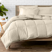 A wooden bed frame with sheets, pillow shams and a comforter on the bed