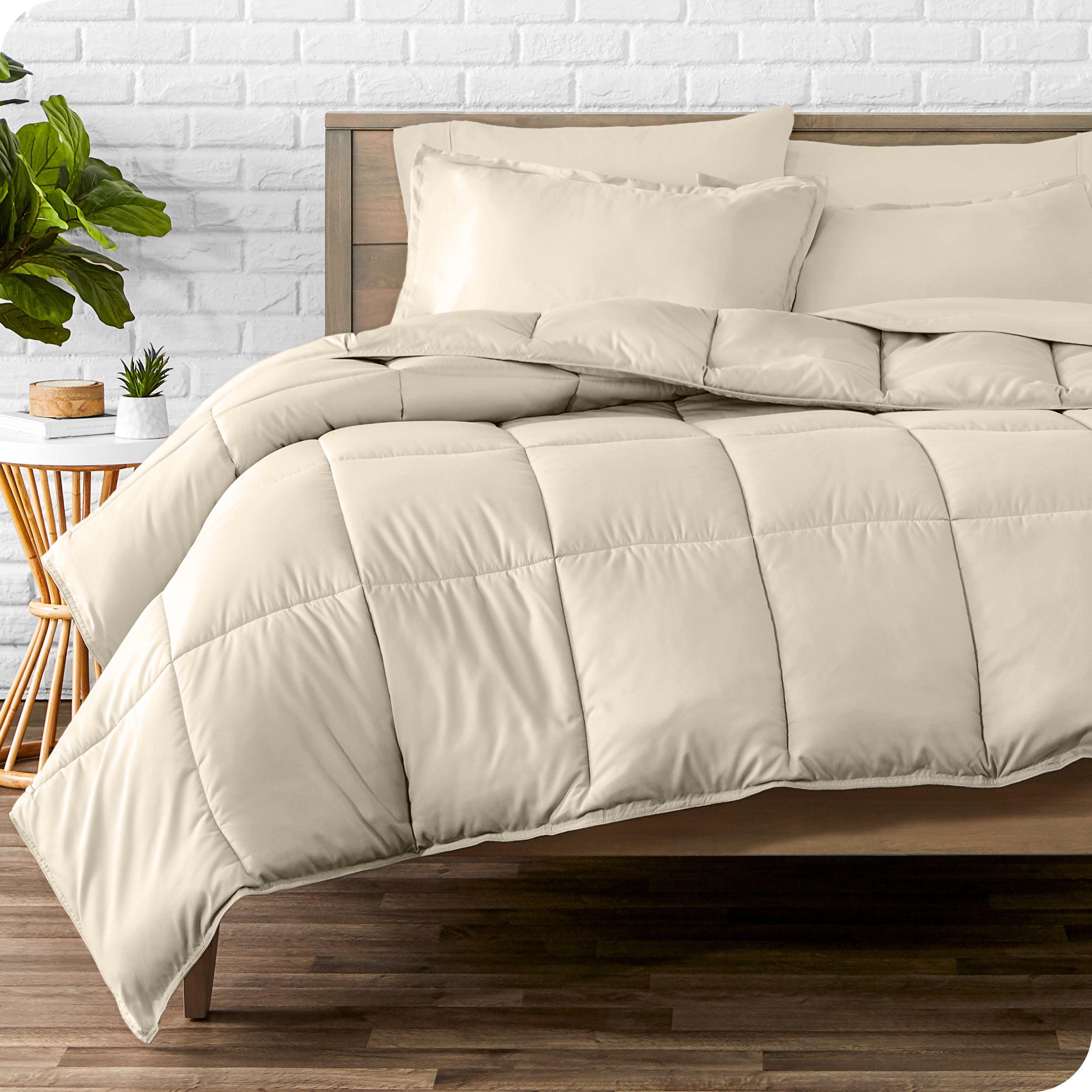 A wooden bed frame with sheets, pillow shams and a comforter on the bed