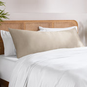 Bamboo pillowcase on a bed with white bedding and a wooden headboard.