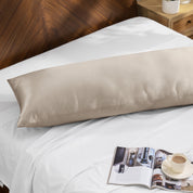 Bamboo body pillow on a bed with a magazine and cup of coffee nearby.