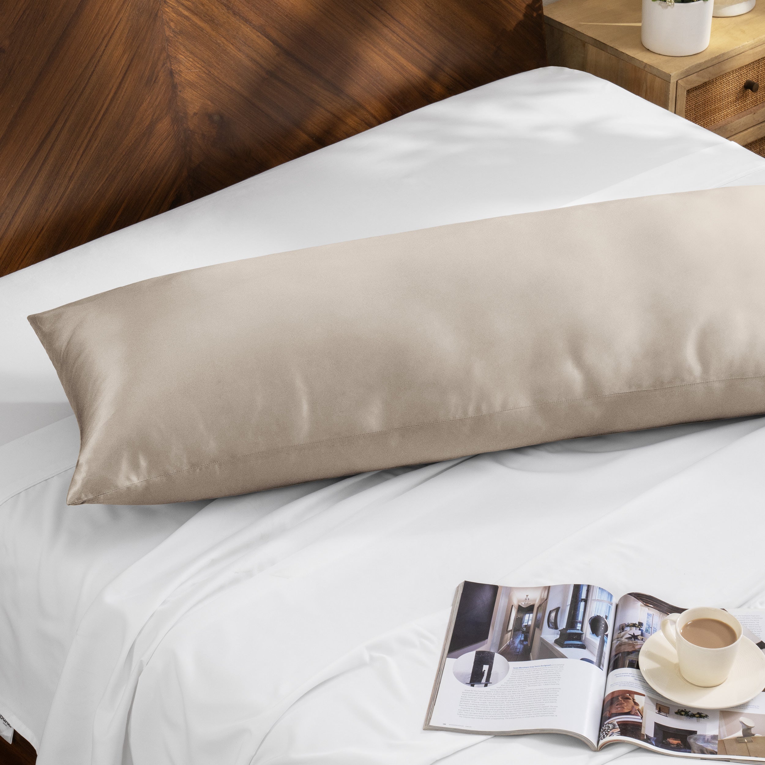 Bamboo body pillow on a bed with a magazine and cup of coffee nearby.