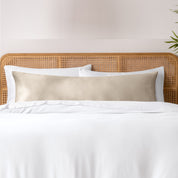 Bamboo body pillowcase on a bed with white bedding and a wicker headboard.