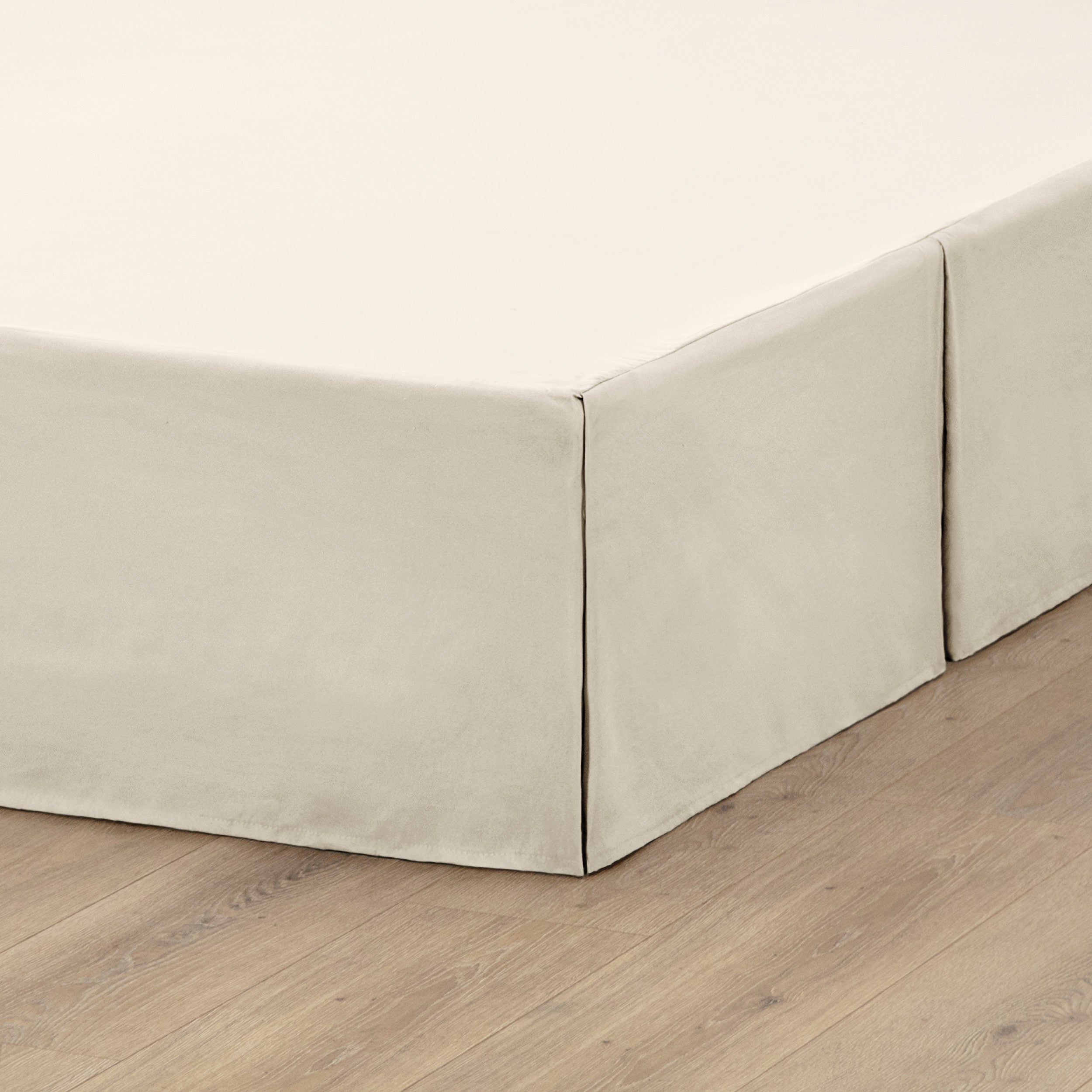 A box spring with a bed skirt on it