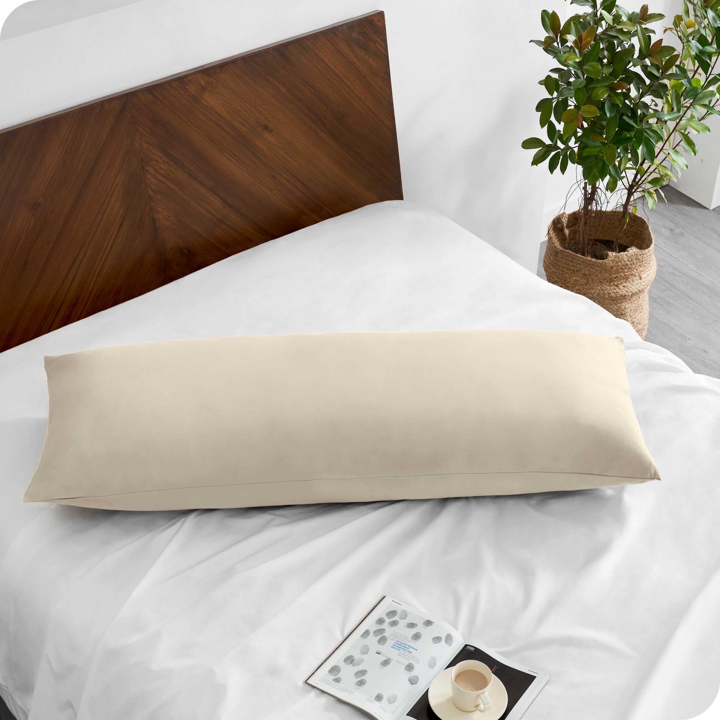 A body pillowcase on a pillow on a bed with all white bedding