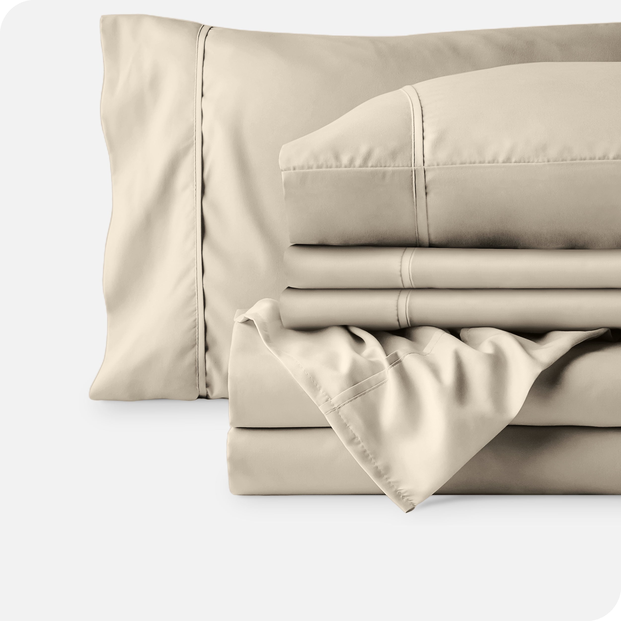 Microfiber sheets neatly folded with corner draped over, two folded pillowcases and two display pillows.