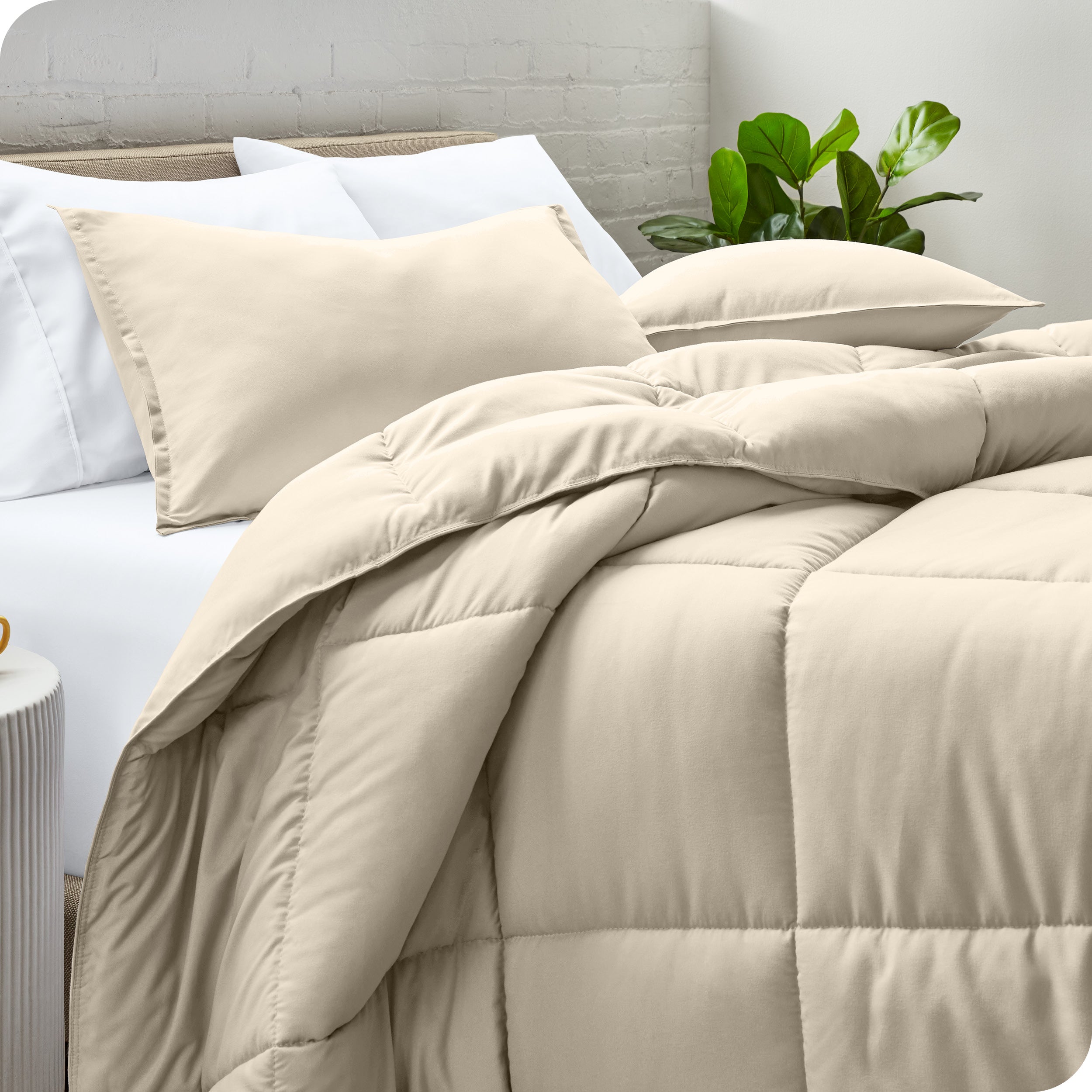 A side view of a modern bed with a comforter set and pillows on the bed