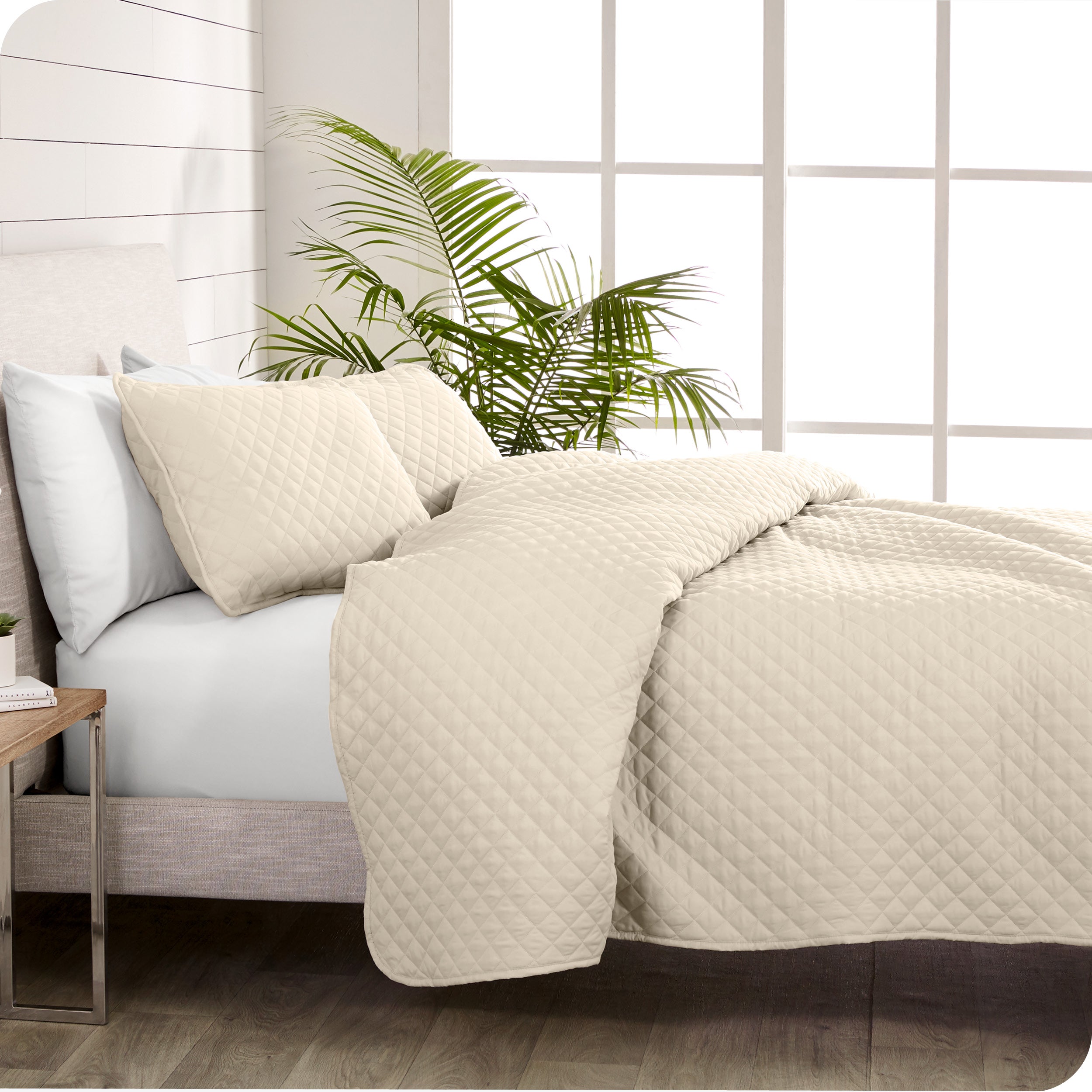 A coverlet set on a bed next to a window