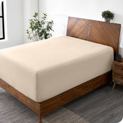 A wide corner view of a modern bed made with a microfiber fitted sheet on the mattress. 