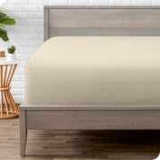 A modern bed with a fitted microfiber sheet on it